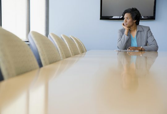 woman sitting alone in boardroom