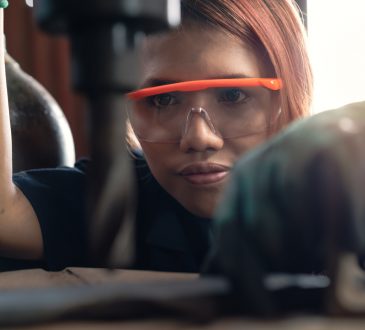 young woman using drill press