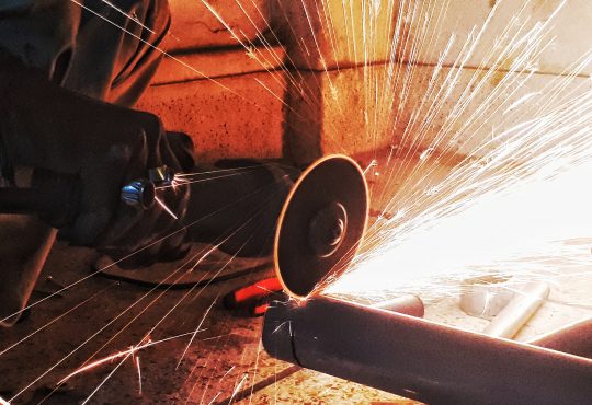 sparks flying as person saws pipe