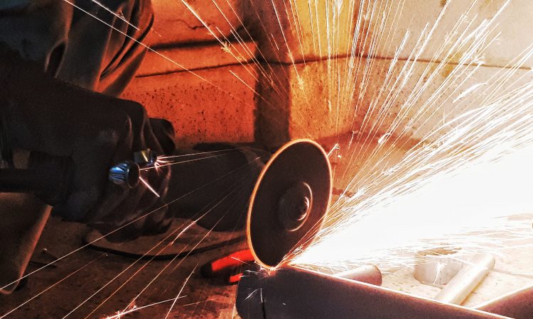 sparks flying as person saws pipe