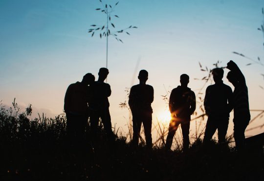 group of young people hanging out in field