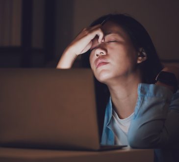 woman sitting at computer looking stressed