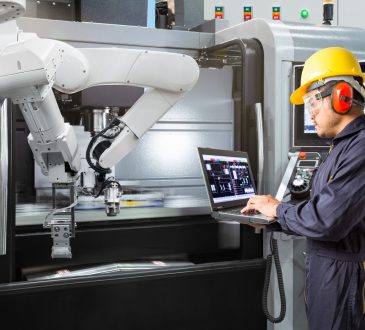 man working with robot machine in factory