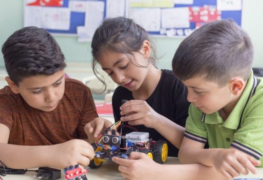 three kids in elementary school classroom