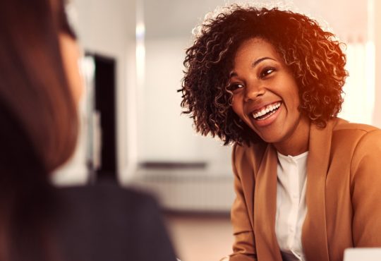 young black businesswoman talking to coworker