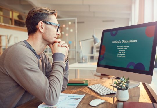 Side view portrait of adult businessman looking at computer screen while preparing for presentation or online conference