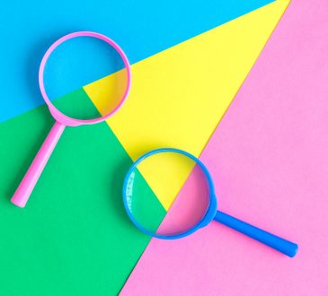 magnifiying glasses on colourful geometric background