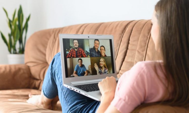 woman sitting on couch during video call on laptop