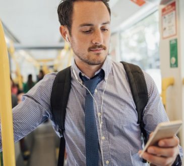 man looking at phone on bus
