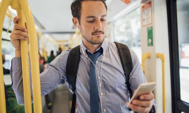 man looking at phone on bus