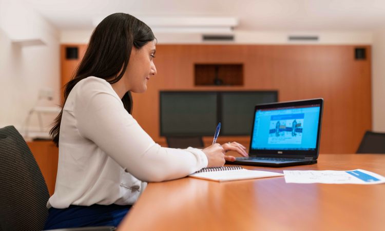 woman using laptop on board room table
