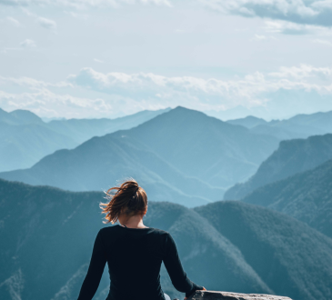 Woman sitting on mountain cliff