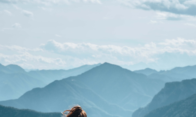 Woman sitting on mountain cliff