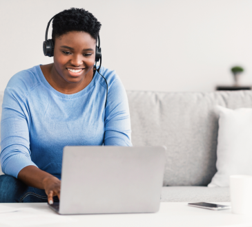 Woman wearing headphones using laptop