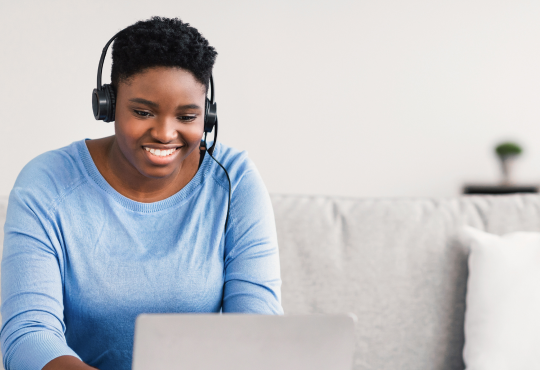 Woman wearing headphones using laptop