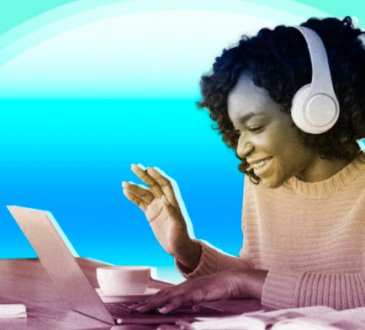 woman wearing headphones and working on laptop