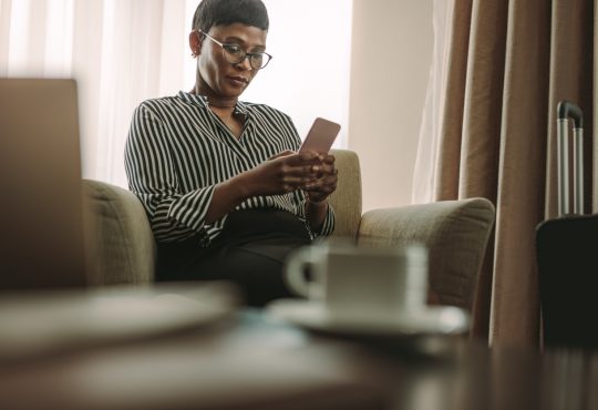 woman reading on cellphone on couch