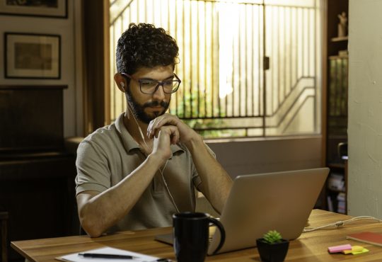 man watching video conference on laptop