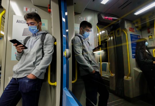 Young man wearing a face mask traveling on the Porto subway