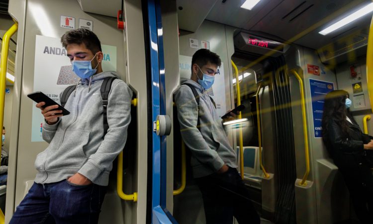 Young man wearing a face mask traveling on the Porto subway