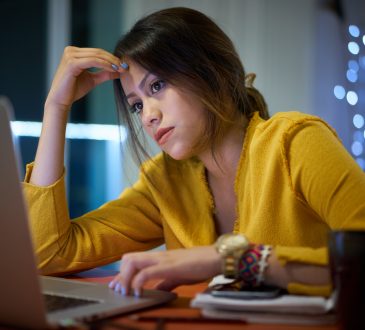 young, tired woman working on laptop