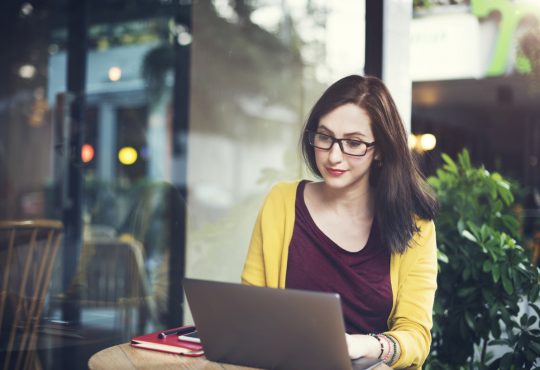 woman using laptop on cafe table