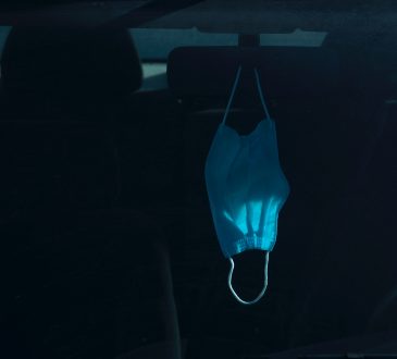 medical mask hanging on car mirror