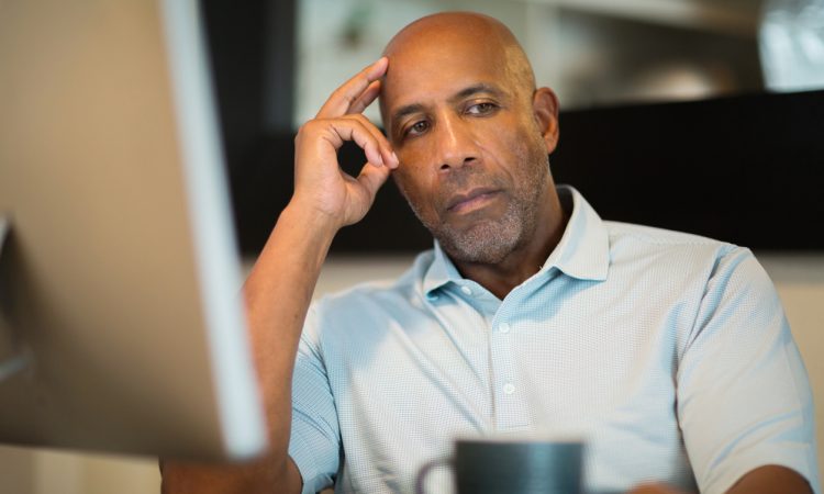 man sitting at desk looking depressed