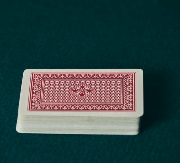 a deck of red cards on the green game mat