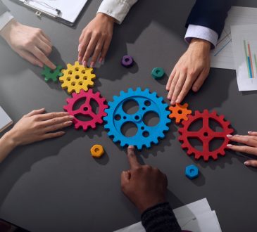 Teamwork of businesspeople work together and combine pieces of gears
