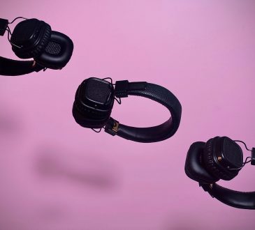three pairs of headphones floating on diagonal line on purple backdrop