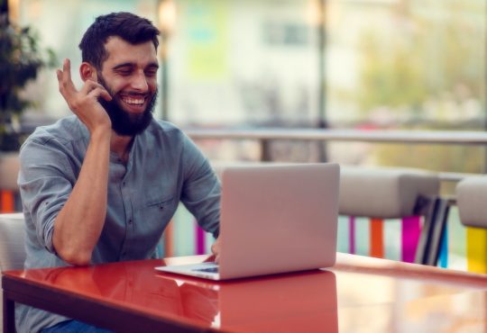 man smiling at laptop