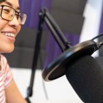 woman recording podcast wearing headphones