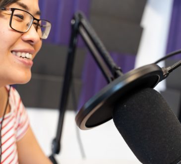 woman recording podcast wearing headphones