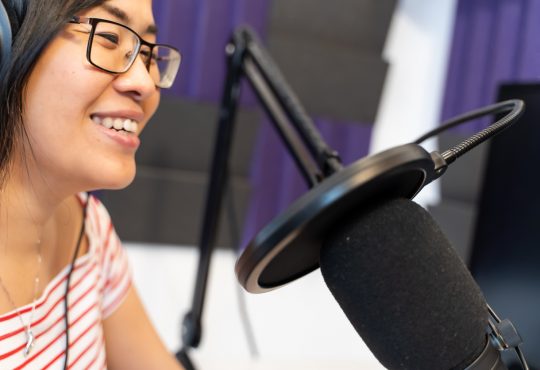 woman recording podcast wearing headphones