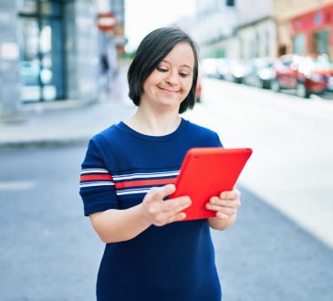 woman with down syndrome using tablet outside