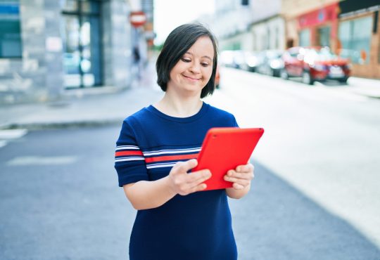 woman with down syndrome using tablet outside