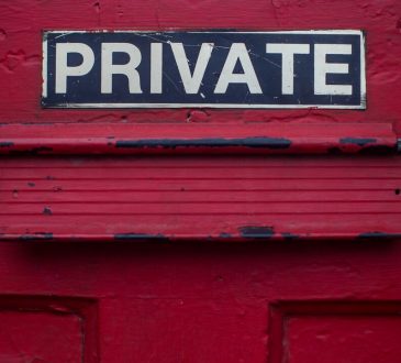private sign above mailbox on red door