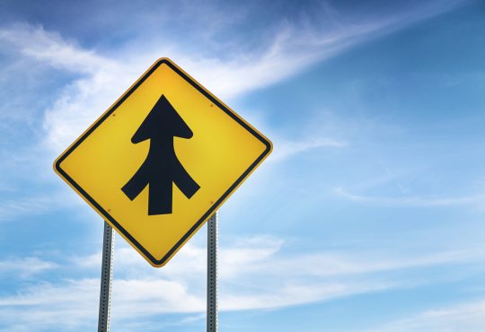 yellow road sign showing three roads merging into one