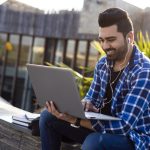 Male student Outdoors on laptop