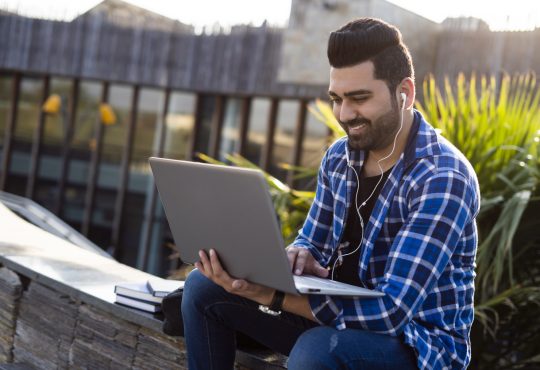 Male student Outdoors on laptop