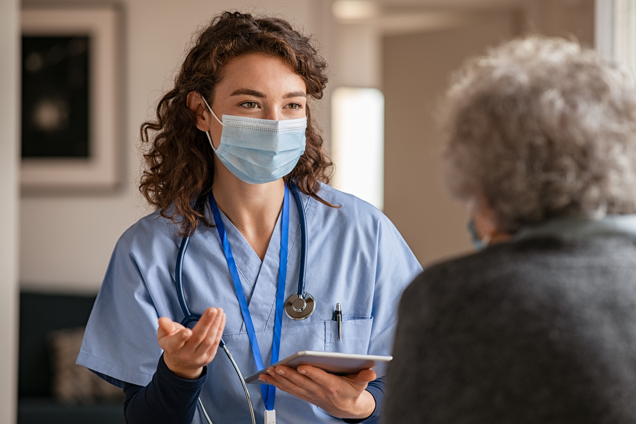 young woman talking to old woman in seniors' home