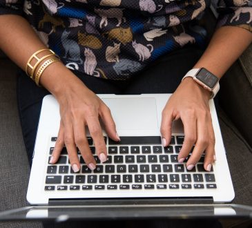 closeup of woman's hands typing on laptop