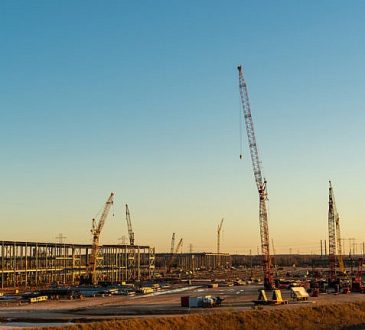 Cranes and large steel columns at Tesla GigaFactory under construction in Austin Texas.