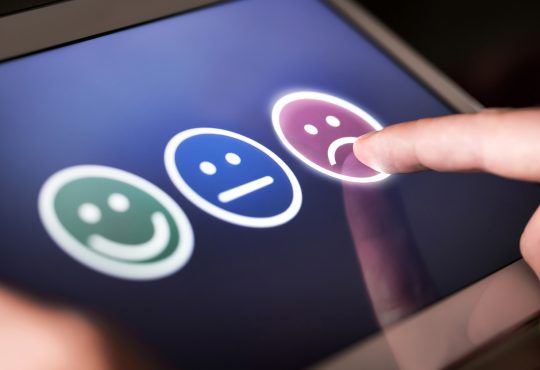 smiley, neutral and sad faces on screen for customer selection