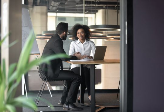 man and woman having meeting in office