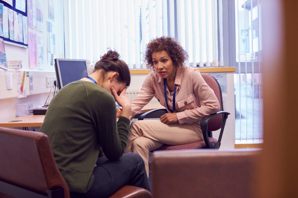 female counsellor and female student with head in hands