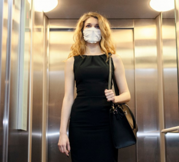 woman wearing business dress and mask in elevator