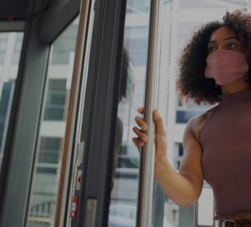 woman entering office building wearing face mask