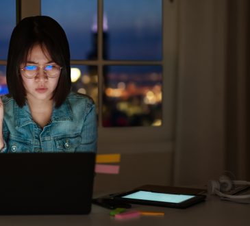 young woman looking at laptop screen suspiciously